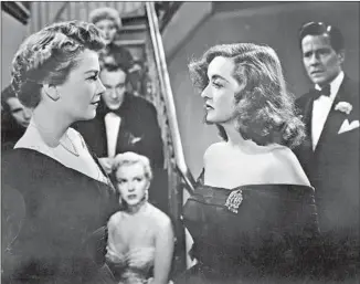  ?? Hulton Archive / Getty Images ?? FASTEN YOUR SEAT BELTS: Eve Harrington (Anne Baxter, left) and Margo Channing (Bette Davis) square off in the 1950 movie “All About Eve.” That’s Marilyn Monroe in the background.