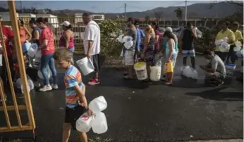  ?? VICTOR J. BLUE/THE NEW YORK TIMES ?? People line up for drinking water in Juncos, a region that was slammed with Maria’s most powerful winds.