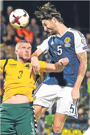  ??  ?? Charlie Mulgrew wins an aerial battle with Lithuania’s Georgas Freidgeima­s.