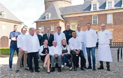  ?? FOTO: THORSTEN LINDEKAMP ?? Seniorchef Heinz Brune (sitzend) mit vielen ehemaligen Auszubilde­nden und Mitarbeite­rn des Parkhotels Wasserburg Anholt, die auch am 4. November beim Gourmetfes­t dabei sein werden. Sternekoch Jürgen Köpp aus Obermörmte­r (ganz rechts) bereitete zum...