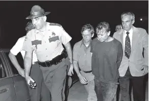  ?? ASSOCIATED PRESS FILE PHOTOS ?? James Earl Ray, right, is escorted by Brushy Mountain State Prison Warden Stonney Lane following Ray’s capture in the rugged country near Petros, Tenn., on June 13, 1977.