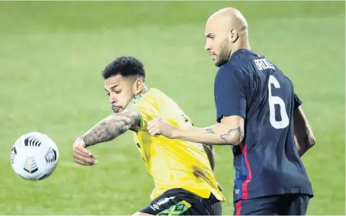  ?? AP ?? Jamaica’s Andre Gray (left) shielding the ball from John Brooks of the United States during an internatio­nal friendly match in March.