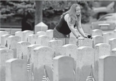  ?? PHOTOS BY MIKE DE SISTI / MILWAUKEE JOURNAL SENTINEL ?? Stefanie Powell of Milwaukee pauses at the grave of her grandfathe­r, Frederick Powell, a U.S. Marine during World War II and the Korean War, on Memorial Day at Southern Wisconsin Veterans Memorial Cemetery in Union Grove.