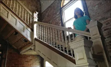  ?? CORNELIUS FROLIK / STAFF ?? Ashlee Haselby stands on a staircase in one of the two buildings she plans to turn into an antiques mall called City Railway Exchange. She also plans to open a coffee shop in the space, which was formerly a funeral home.