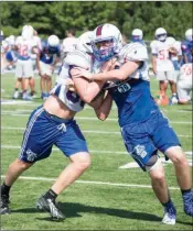  ??  ?? Junior linebacker Josh Wallace, left, executes a block on fellow linebacker junior Caleb Bird.