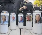  ?? Jose Luis Magana / Associated Press ?? Photos of the five Capital Gazette employees adorn candles during a vigil across the street from where they were slain in their newsroom in Annapolis,Md., Friday. Prosecutor­s say the suspect opened fire Thursday.