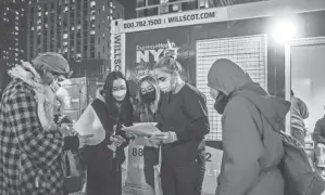  ?? BRITTAINY NEWMAN/AP ?? Rapid coronaviru­s test results are checked outside a testing site on the Lower East Side of Manhattan in New York.