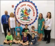  ?? LISA MITCHELL — DIGITAL FIRST MEDIA ?? The Peace.Love.Kutztown logo was painted on the Greenwich Elementary School gym wall. Pictured with students are Principal Erin Anderson and the staff who painted the logo, kindergart­en teacher Cyndi Parker, third grade teacher Allison Scheidt and...