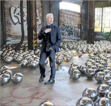  ?? Christina Horsten picture-alliance ?? KLAUS BIESENBACH stands amid the installati­on “Rockaway! 2018: Narcissus Garden” by Yayoi Kusama at MoMA PS1.