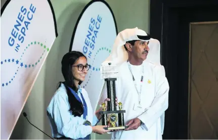  ?? Photos Christophe­r Pike / The National ?? Mohammed Al Ahbabi, director-general of the UAE Space Agency awards, presents Alia Al Mansoori, 14, from Al Mawakeb school in Dubai, with the top prize for the UAE Genes in Space competitio­n during the Global Space Congress.