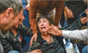  ?? (AFP) ?? Relatives of Royal Sahnazarov, his wife Zuleyha Sahnazarov­a and their daughter Medine Sahnazorav­a, who were killed when a rocket hit their home, mourn during their funeral in the city of Ganja, Azerbaijan, on Saturday during fighting over the breakaway region of Nagorno-Karabakh.