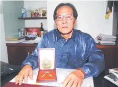  ??  ?? Hii displaying the gold-plated commemorat­ive medal to be presented on Sept 20.