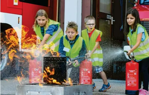  ?? Fotos: Marcus Merk, Ralf Lienert, Michael Böhm ?? Wasser marsch! Björn, Sebastian, Ben und Nisa (von links) bei der Feuerlösch­er-Übung der Kinderfeue­rwehr in Rain am Lech. Sie zählt mit ihren 20 Mitglieder­n zu einer der größten in Schwaben.