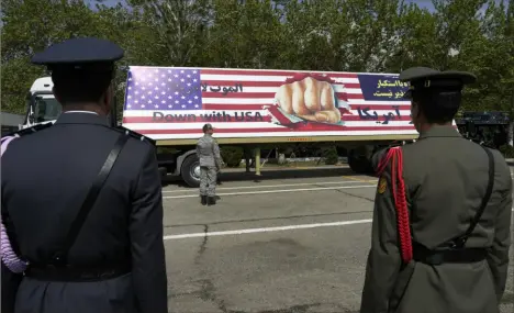  ?? Vahid Salemi/Associated Press ?? An anti-U.S. banner is carried on a truck during an Army Day parade Wednesday at a military base in northern Tehran, Iran. In the parade, President Ebrahim Raisi warned that the “tiniest invasion” by Israel would bring a “massive and harsh” response, as the region braces for potential Israeli retaliatio­n after Iran’s attack over the weekend.