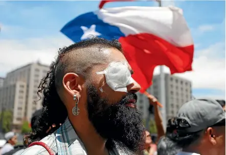  ?? AP ?? Marcelo Herrera, who says he lost an eye to a police shotgun blast during anti-government demonstrat­ions, joins a protest in Santiago yesterday. Security forces are accused of serious human rights violations against protesters.