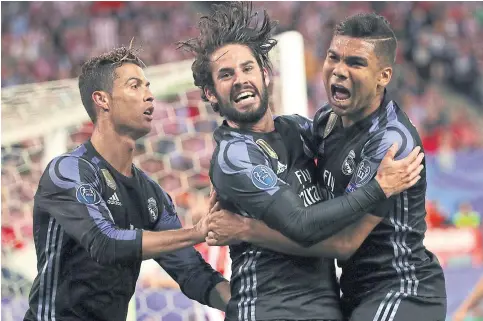  ??  ?? Real Madrid’s Isco, centre, celebrates scoring against Atletico in the Champions League semi-final second leg with Casemiro, right, and Cristiano Ronaldo.