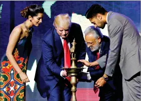  ??  ?? Republican Hindu Coalition chairman Shalli Kumar (2nd R) helps Republican presidenti­al nominee Donald Trump light a ceremonial lamp before he speaks at a Bollywood-themed charity concert put on by the Republican Hindu Coalition in Edison, New Jersey,...