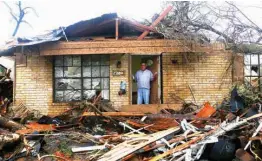  ?? The San Antonio Express-News via AP ?? Greg Goza stands in the doorway of his 90-year-old mother-in-law’s home after severe weather swept through a neighborho­od Monday in north central San Antonio. His motherin-law was not harmed, but the home is in shambles.