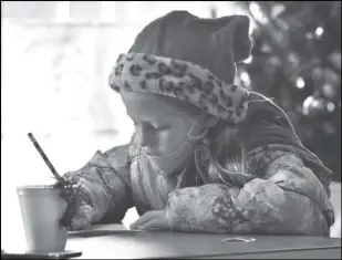  ?? Staff photo/ Teresa Dowling ?? Elise Goodyear pens her letter to Santa in New Knoxville Village Hall on Saturday afternoon. The letters could then be taken next door to the post office to be sent to the North Pole.