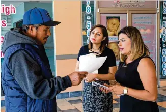  ?? STEVE SCHAEFER / SPECIAL TO THE AJC ?? Carolina Montilla (right) and Viviana Cossio talk to a shopper about enrolling in health insurance under the Affordable Care Act at the Santa Fe Mall in Duluth on Saturday.