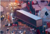  ?? — AFP ?? Forensic experts examine the scene around a truck that crashed into a Christmas market in Berlin on Tuesday.