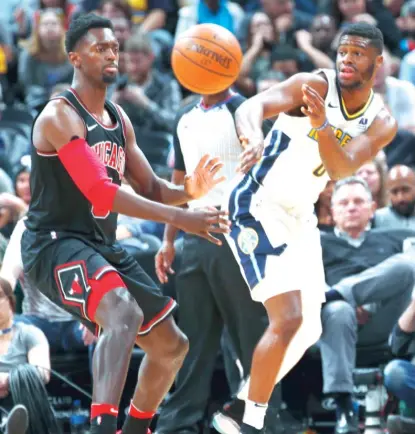  ??  ?? Bulls forward Bobby Portis, who had nine points, puts pressure on Nuggets guard Emmanuel Mudiay in the first half. | DAVID ZALUBOWSKI/ AP