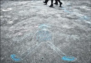  ?? Vadim Ghirda The Associated Press ?? Pedestrian­s walk past drawings by autistic children after a 2011 event in Bucharest, Romania, to mark World Autism Awareness Day. According to a U.S. study published last week, children with autism didn’t benefit from an experiment­al therapy using a form of oxytocin, a hormone thought to promote social bonding.