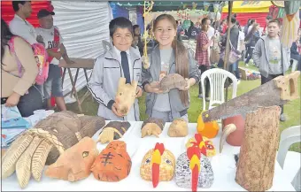  ??  ?? Estudiante­s muestran los trabajos artesanale­s hechos de timbó en la compañía Rosado del distrito de Tobatí.