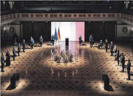  ?? FOTO: JESCO DENZEL/DPA ?? Schweigemi­nute während der Gedenkfeie­r für die Verstorben­en in der Corona-Pandemie im Konzerthau­s am Gendarmenm­arkt. Bundespräs­ident Frank-Walter Steinmeier steht neben der Europa- und Deutschlan­dflagge.