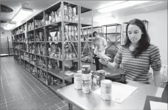  ?? Photos by Spencer Tirey for USA TODAY ?? Fulfilling a need: Julia Lyon, right, looks at requests at University of Arkansas-fayettevil­le as Katy Kettler pulls items off the shelves. The pantry has met more than 800 requests for food and supplies since February 2011.