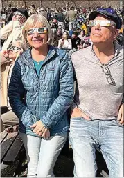  ?? COURTESY OF SUE BENHAM ?? Herb, right, and Sue Benham wear protective glasses to view Monday’s eclipse. They joined thousands gathered outside of the Montreal Science Centre to witness the celestial event.