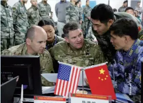  ??  ?? Chinese and US military personnel talk with each other during joint humanitari­an relief and disaster rescue drills, Kunming, Yunnan Province, November 18, 2016