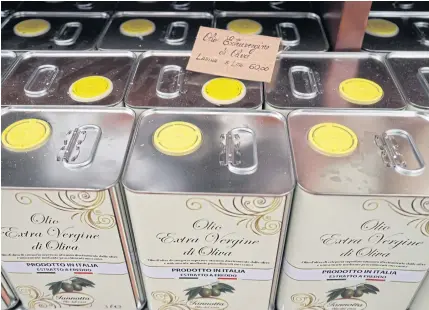  ?? AP ?? Cans of Italian extra virgin olive oil are on sale at the Iannotta family olive oil farm’s shop in Capocroce, Italy.