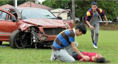  ?? PHOTOS: KEVIN FARMER ?? ROAD SAFETY: TACAPS students (from left) Joseph Goh, Jasmine Barui (on the ground) and Kalisi Fonua act out a fatal car crash scenario as part of road safety education program produced by the RACQ.