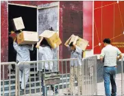  ?? Ng Han Guan ?? The Associated Press Workers carry boxes of LED lights into a renovation site Tuesday in Beijing.