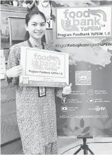  ??  ?? POSTER: Ann Leen bersama poster Program Foodbank YAPEIM 1.0 pada majlis itu.