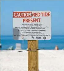  ?? TIFFANY TOMPKINS/TNS ?? A red tide warning sign is posted on a public beach during a past algal bloom.