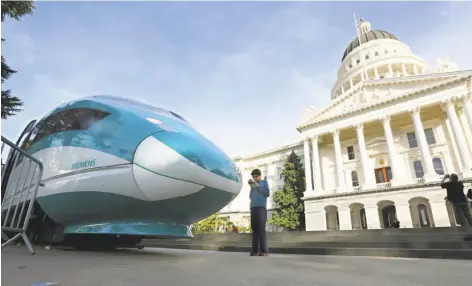  ?? Rich Pedroncell­i / Associated Press ?? A mock-up of a high-speed train sits in front of the Capitol in Sacramento. The passage of Prop. 53 could threaten the project.