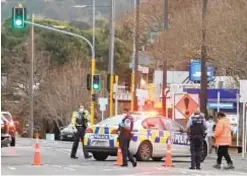  ??  ?? Police in New Zealand guard the area where an ISIS-inspired fiend stabbed six people at random at a supermarke­t before being killed.