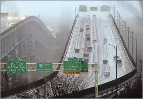  ?? TIM MARTIN/THE DAY ?? Motorists travel on Interstate 95 southbound, left, and northbound, right, in January of last year as they cross the Gold Star Memorial Bridge in rain and fog.