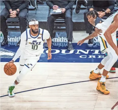  ?? ISAAC HALE, AP ?? Utah Jazz guard Mike Conley (10) drives the ball toward the hoop after losing Memphis Grizzlies guard Ja Morant on a screen set by Jazz center Rudy Gobert in a game on March 26, 2021, in Salt Lake City.