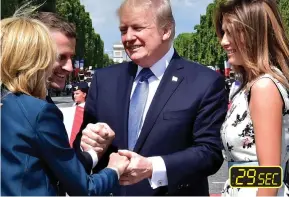  ??  ?? Going for a record: Trump leans in to kiss Brigitte Macron before reaching to hold her hand too