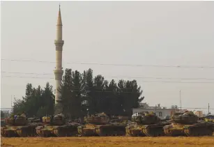  ?? (Reuters) ?? TURKISH ARMY tanks are stationed along the Turkish-Syrian border in the southeaste­rn Gaziantep Province last year.