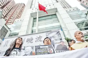  ?? — Gambar AFP ?? AKTIVIS prodemokra­si termasuk ‘Si Rambut Panjang’ (kiri) berhimpun di luar pejabat perhubunga­n China di Hong Kong semalam untuk menandakan ulang tahun pertama kematian Liu Xiaobo.