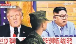  ??  ?? A South Korean soldier watches a TV screen showing pictures of Trump and Kim. AFP
