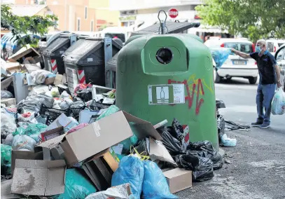  ?? REUTERS ?? A man throws a garbage bag at a full rubbish bin, in Rome, Italy, June 25, 2021.