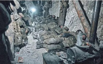  ?? LIBKOS/AP ?? Ukrainian soldiers rest after fighting near Bakhmut, Ukraine, Saturday. Ukrainian officials say Moscow is having trouble launching a large-scale offensive in the east of the country.