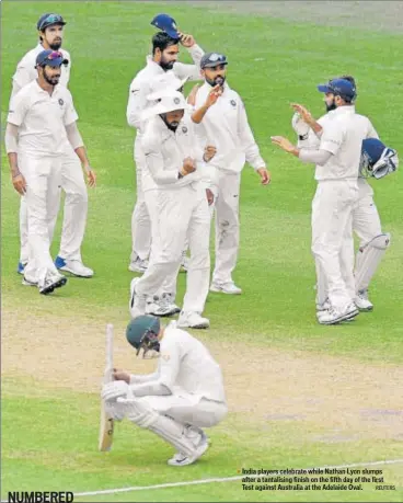  ?? REUTERS ?? India players celebrate while Nathan Lyon slumps after a tantalisin­g finish on the fifth day of the first Test against Australia at the Adelaide Oval.