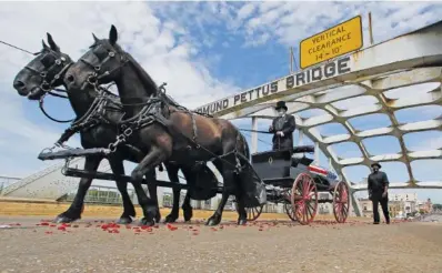  ?? AP PHOTO/JOHN BAZEMORE ?? The casket of U.S. Rep. John Lewis moves over the Edmund Pettus Bridge by horse-drawn carriage during a memorial service Sunday in Selma, Ala.