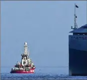  ?? PETROS KARADJIAS/AP ?? One of three ships belonging to the Open Arms aid group, loaded with canned food and other supplies, leaves the island of Cyprus on Saturday on a humanitari­an mission to Gaza. A French warship is alongside.